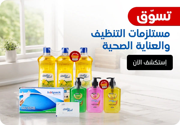 Shop Cleaning & Hygiene Essentials banner featuring Soft & Cool dish washing liquid triple pack with special offer, Soft & Cool hand wash in green, pink, and yellow variants with special offer, Hotpack clear powder-free vinyl gloves box, and Soft & Cool soap bar displayed on a bright kitchen countertop background with Explore Now call to action. | بانر تسوق مستلزمات التنظيف والعناية الصحية يعرض سائل غسيل الأطباق سوفت آند كول ثلاث قطع بعرض خاص، غسول اليدين سوفت آند كول بألوان أخضر وزهري وأصفر بعرض خاص، علبة قفازات فينيل شفافة خالية من البودرة من هوت باك، وصابون سوفت آند كول معروضة على خلفية طاولة مطبخ مضيئة مع زر إستكشف الآن.