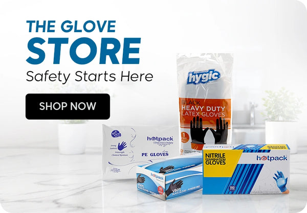 The Glove Store banner featuring Hygic black heavy duty latex gloves resealable bag, Hotpack PE gloves box, Hotpack black vinyl gloves powder-free box, and Hotpack nitrile examination gloves box displayed on a clean white marble countertop with Safety Starts Here tagline and Shop Now call to action. | بانر متجر القفازات يعرض كيس قفازات لاتكس هيفي ديوتي سوداء هيجيك، علبة قفازات PE هوت باك، علبة قفازات فينيل سوداء خالية من البودرة هوت باك، وعلبة قفازات نيتريل للفحص هوت باك معروضة على طاولة رخامية بيضاء نظيفة مع شعار السلامة تبدأ من هنا وزر تسوق الآن.